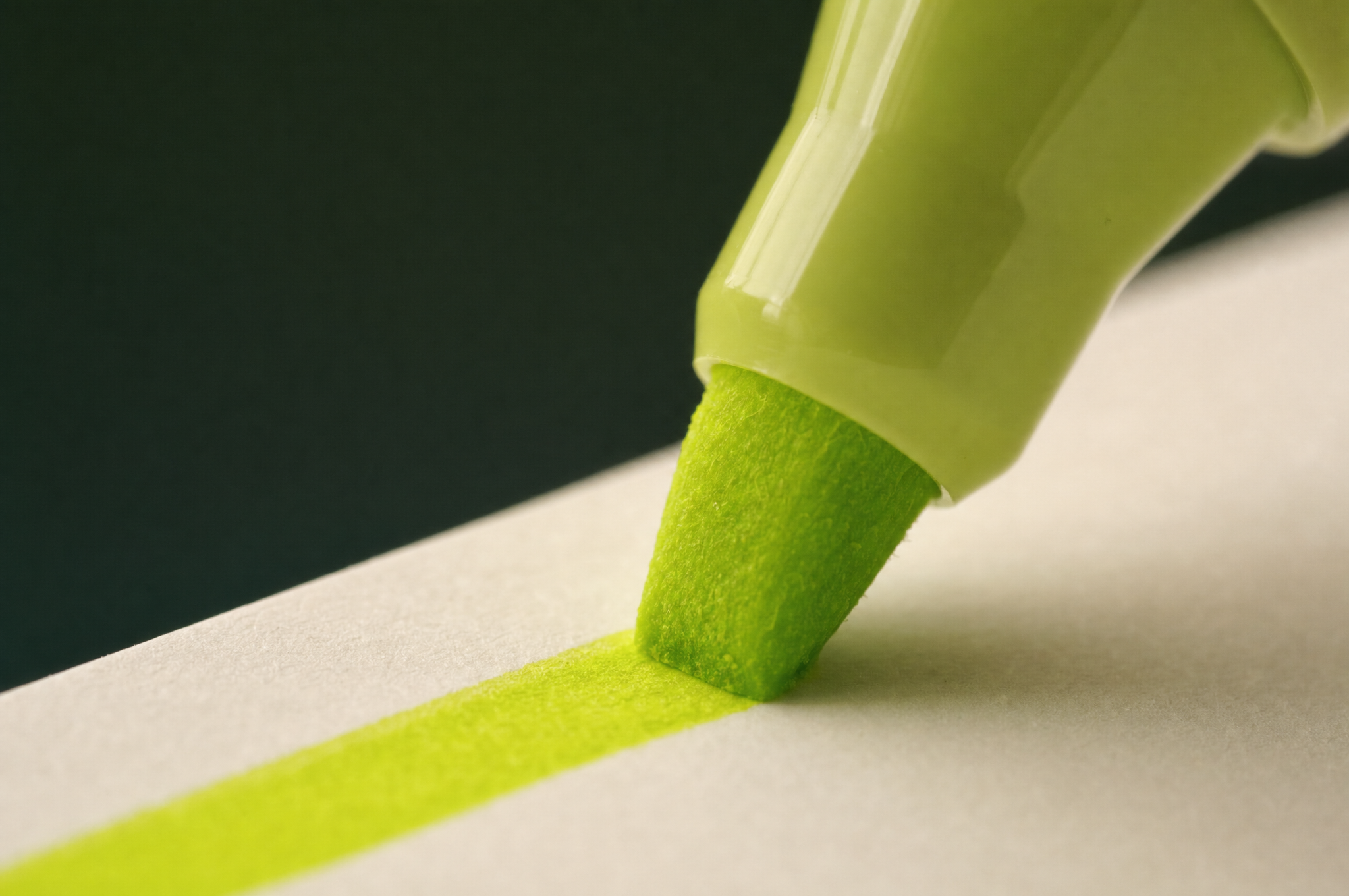 A chartreuse highlighter sweeping a single line across warm paper